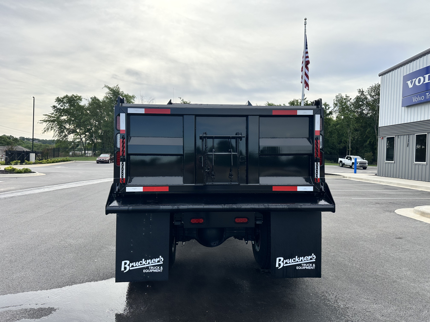 Rear view of a black dump truck bed on a 2025 Hino L7 chassis showing Bruckner’s mud flaps and reflective striping.