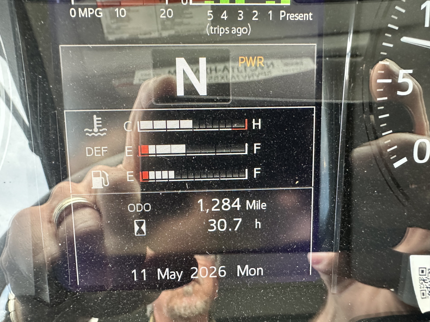 Dashboard display showing N transmission, PWR indicator, coolant/DEF/fuel gauge bars, and ODO 1,284 miles with 30.7 hours; 11 May 2026 Mon.