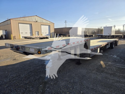 Wide view of a used 2019 Reitnouer drop deck trailer in a lot, showing a low-profile flatbed with multiple axles. No legible close text visible in the image itself.
