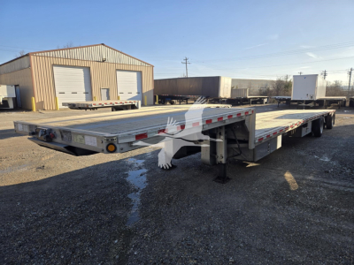 Used 2019 Reitnouer Dropmiser trailer with drop deck, seen from left-rear angle; shows low profile deck, multiple axles, landing gear, and reflective tape.