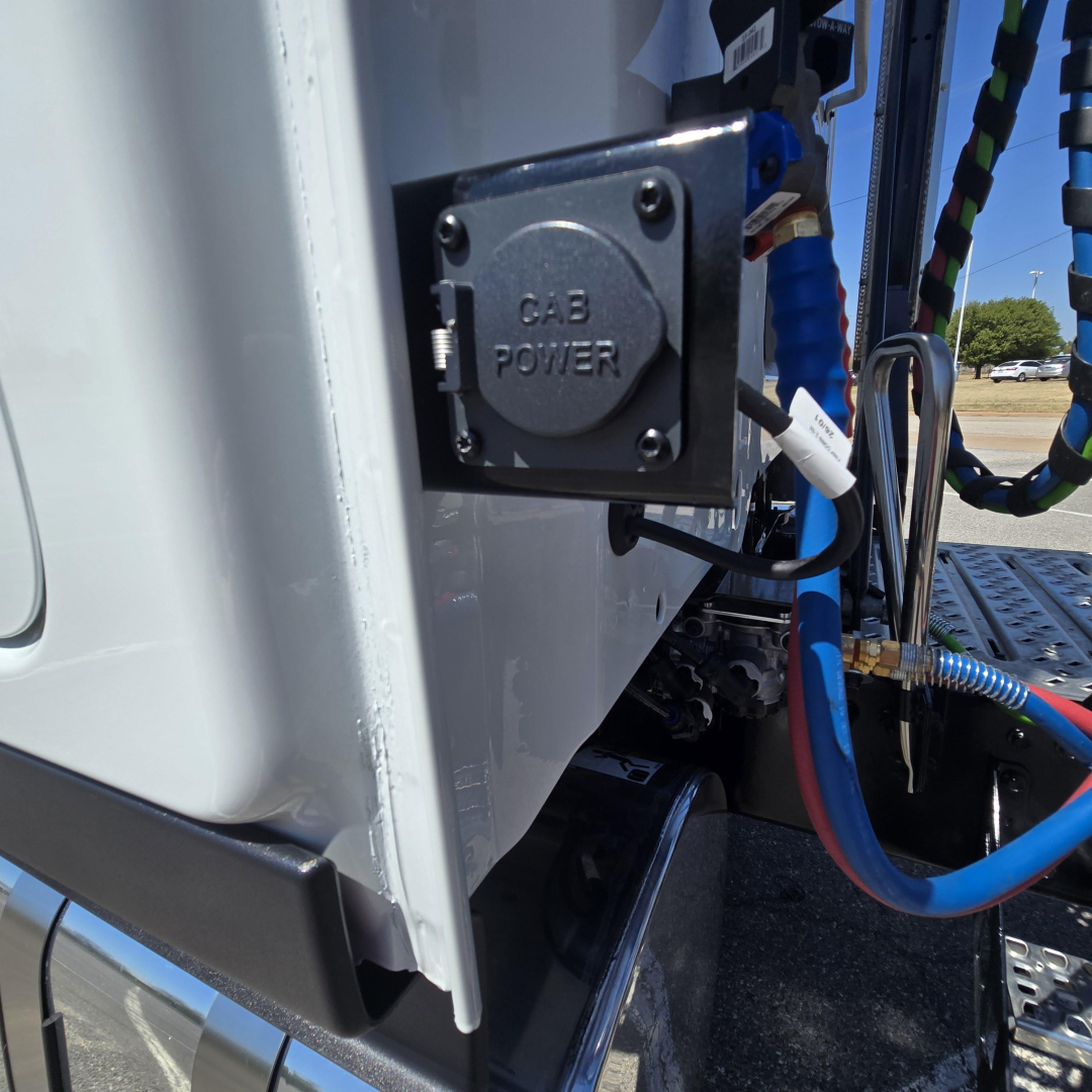 Truck cab area showing CAB POWER power inlet and blue/red cables entering the side of the Mack PR64T76M cab