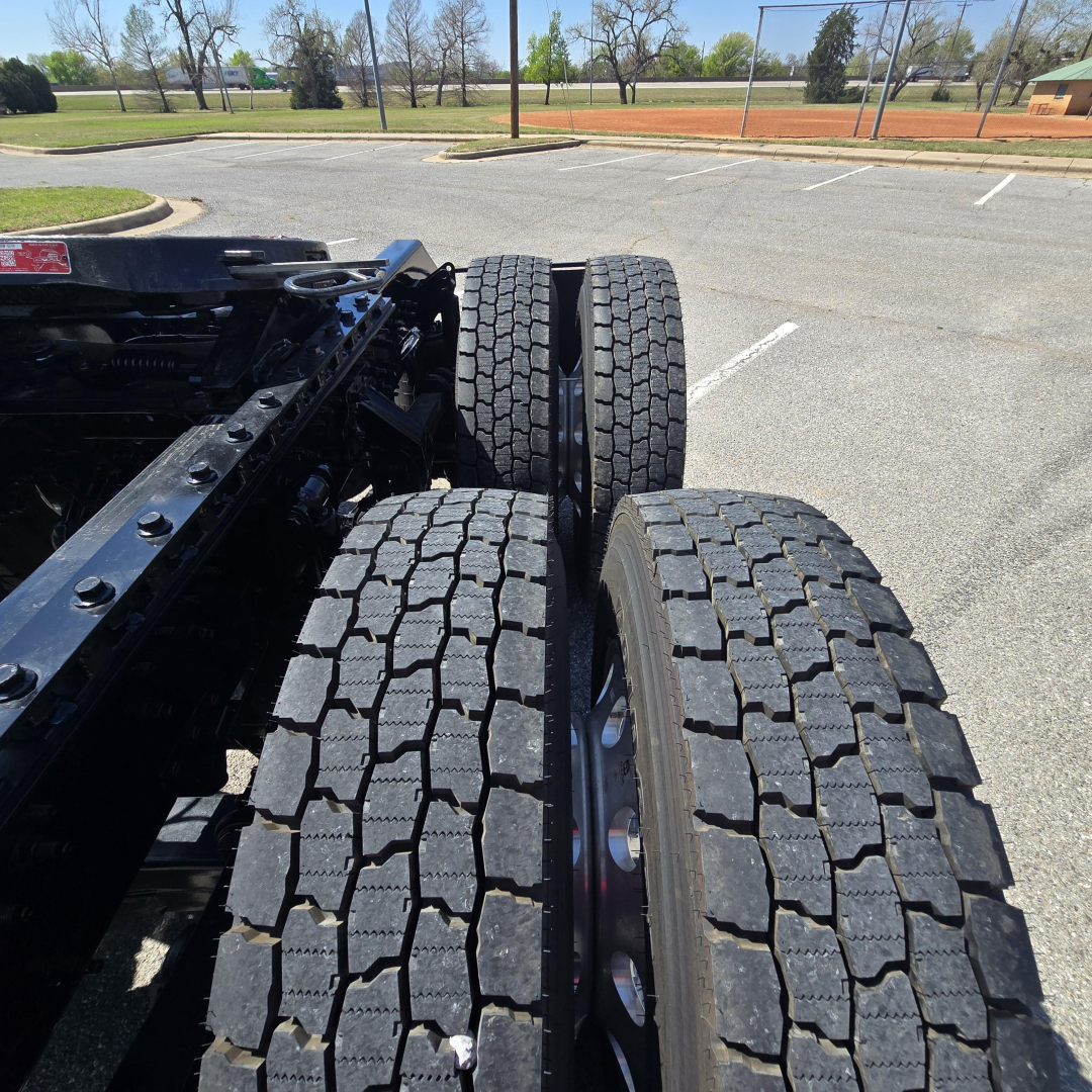 Mack PR64T76M truck chassis showing dual rear tandem axles with heavy-duty tires and tread pattern.