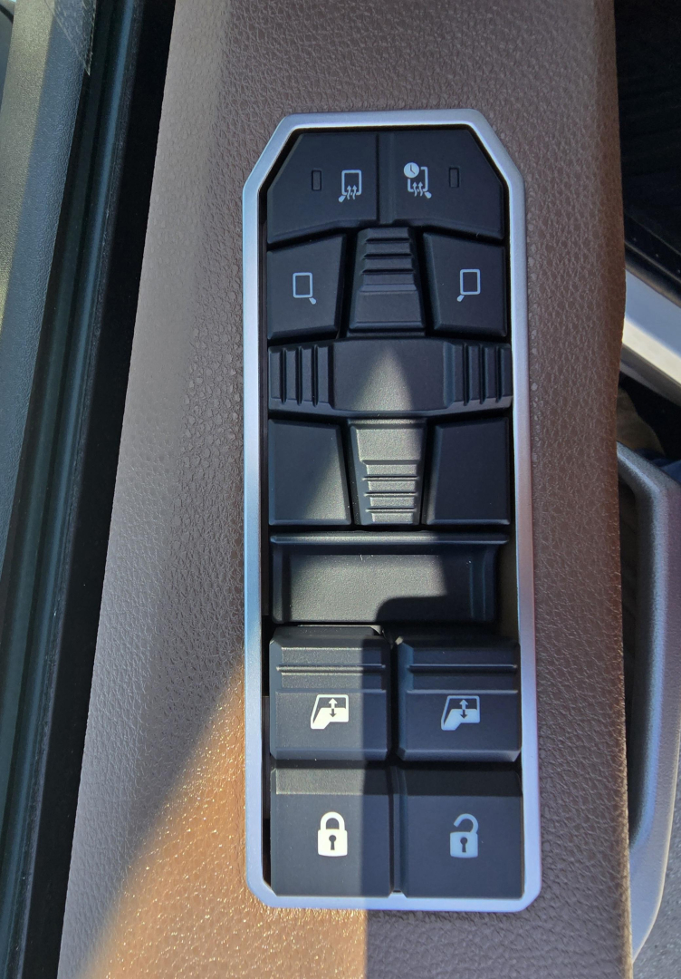 Truck interior control panel on a Mack PR64T76M showing window/lock control buttons and a storage area.