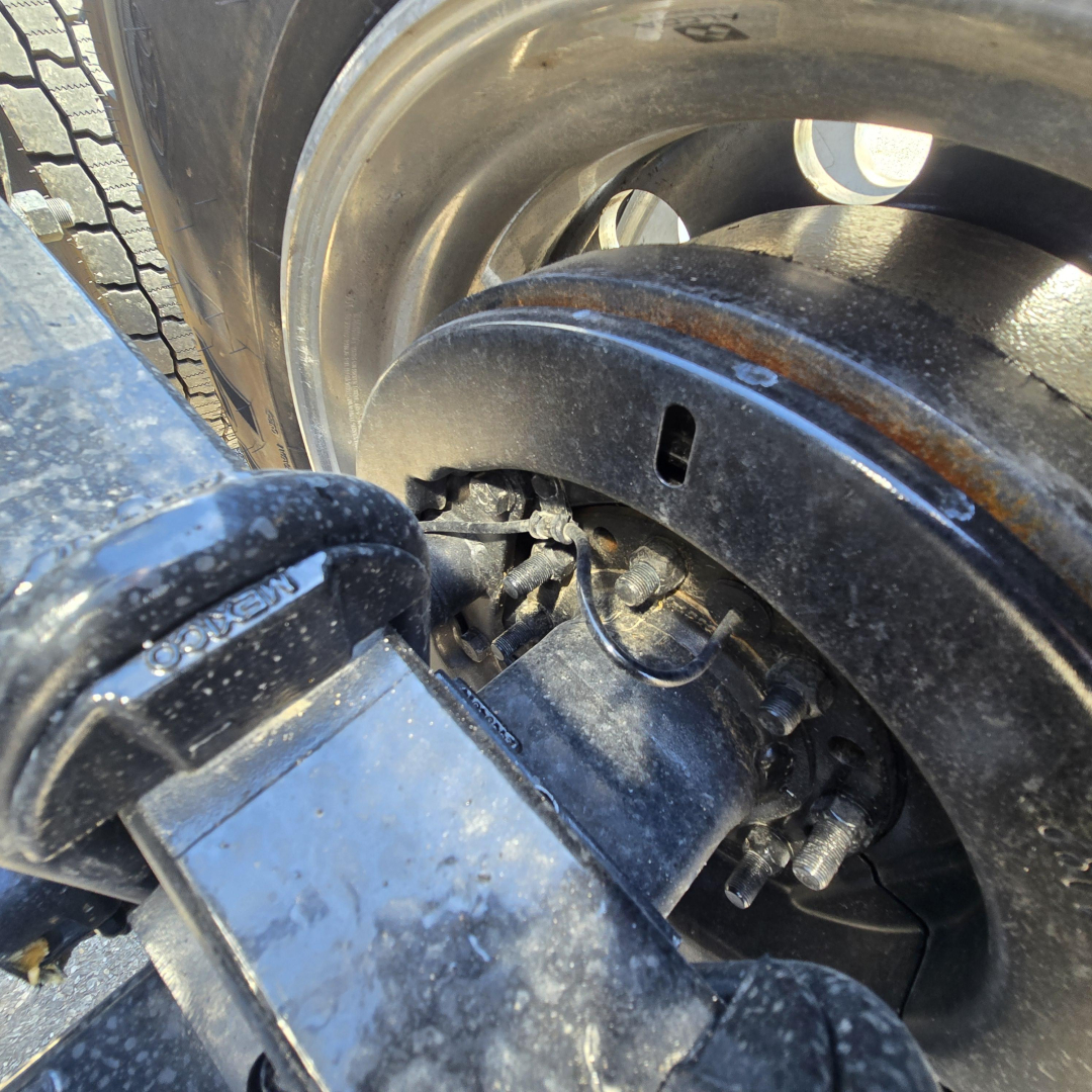 Mack PR64T76M truck component close-up showing wheel and suspension/airline hardware with hub area.