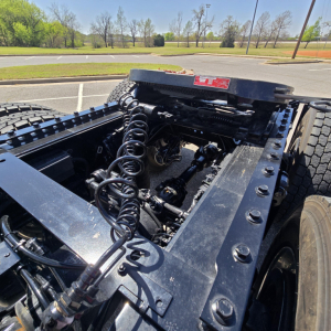 Chassis and air lines of a new Mack PR64T76M tractor showing hydraulic hoses and frame components.