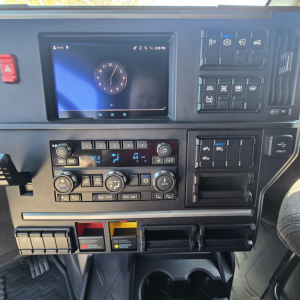 Dashboard of a 2027 Mack PR64T76M truck showing a touchscreen display and climate controls, various switches, and control panels.