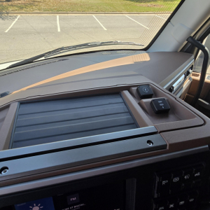 Dashboard view of 2027 Mack PR64T76M interior showing dashboard trim, console controls, and cupholder area.