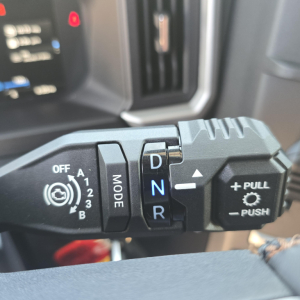 Truck gear selector stalk with D N R showing on the lever, plus PULL to operate and MODE switch.