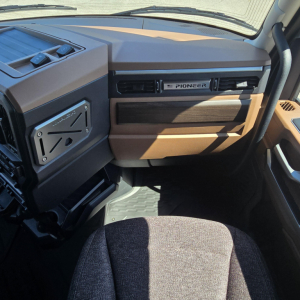 Interior dashboard of a Mack truck cab showing Pioneer radio badge on the dash and beige/brown trim, steering wheel on right side, driver seat in foreground.