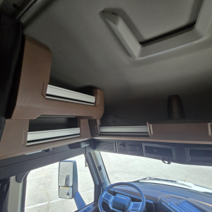 Cab interior of a new Mack PR64T76M sleeper truck showing overhead bunks and dash with steering wheel
