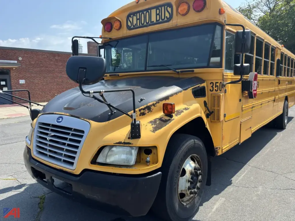 School bus side view showing front grille, hood and windshield with 'SCHOOL BUS' sign on top and yellow body; front tire and bumper visible.