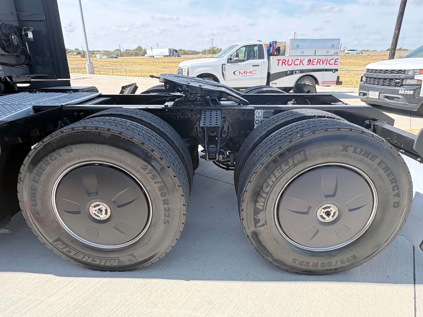 Kenworth T680 rear axle with dual tires on a flatbed chassis, no engine bay view; tire sidewalls show Michelin X (Michelin) branding.