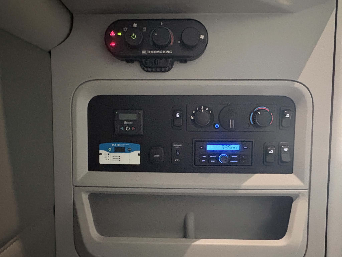 Kenworth T680 interior dash showing climate controls and stereo head unit with digital display and climate vents.