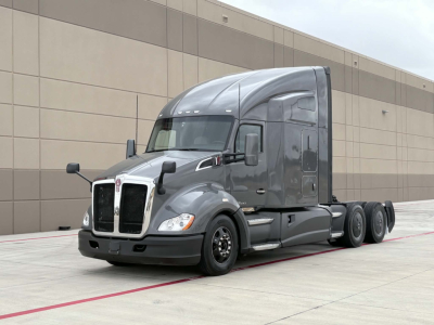 Kenworth T680 tractor-trailer in a parking lot, front-left view, with no visible text on the vehicle