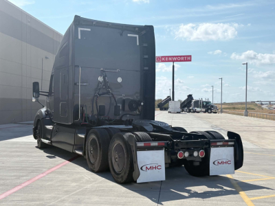Kenworth T680 tractor rear view showing fifth wheel, rear fenders, and mud flaps with MHC logo.
