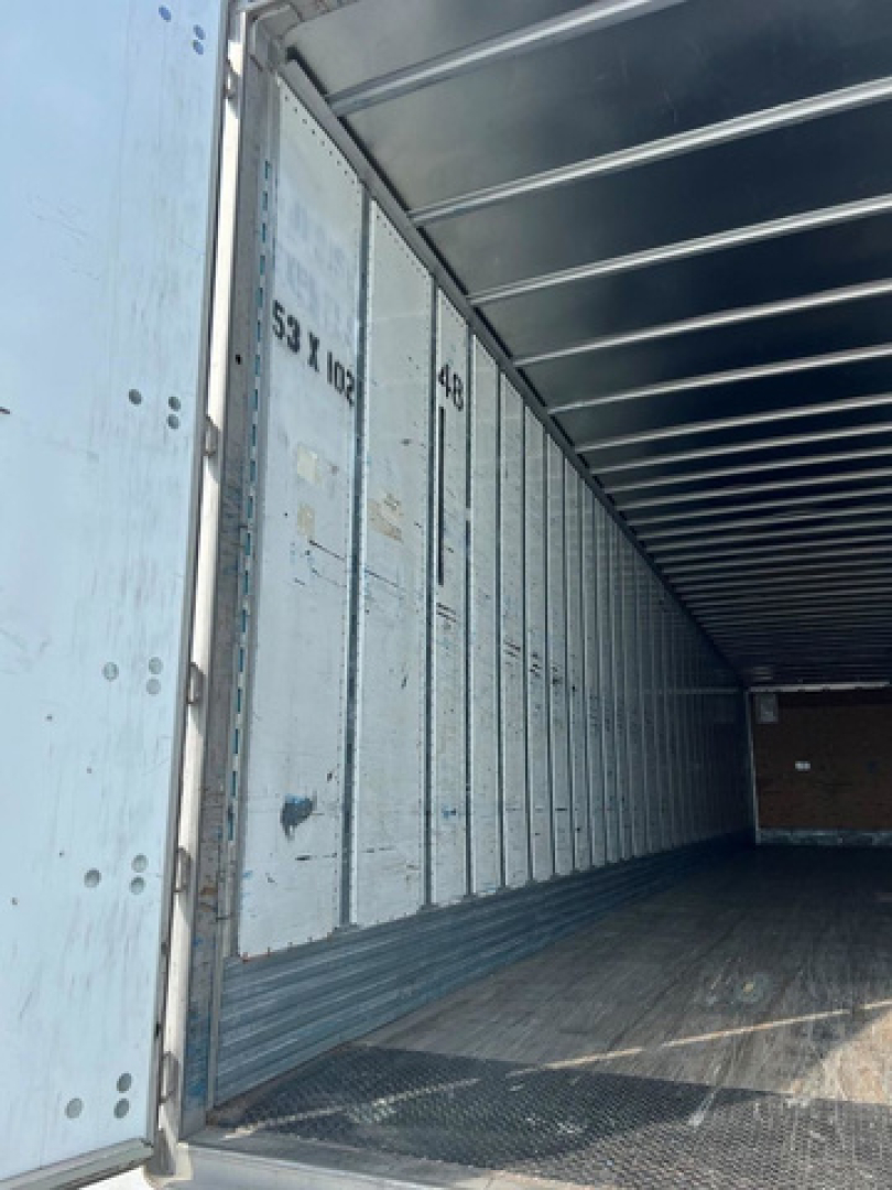 Trailer van interior showing metal panels and empty cargo space with ribbed ceiling and sidewalls.