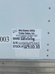 Label on trailer showing 2014 Mid-States Utility Trailer Sales, Inc. make Utility, S/N JUVS2536EP818203, STOCK U91070.