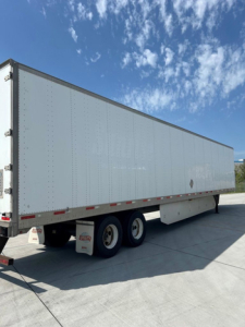 Utility van trailer showing side view with white exterior and dual rear axles.