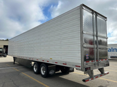 Trailer side view showing a 53-ft silver refrigerated utility trailer with tandem axles and diamond-plate rear doors.