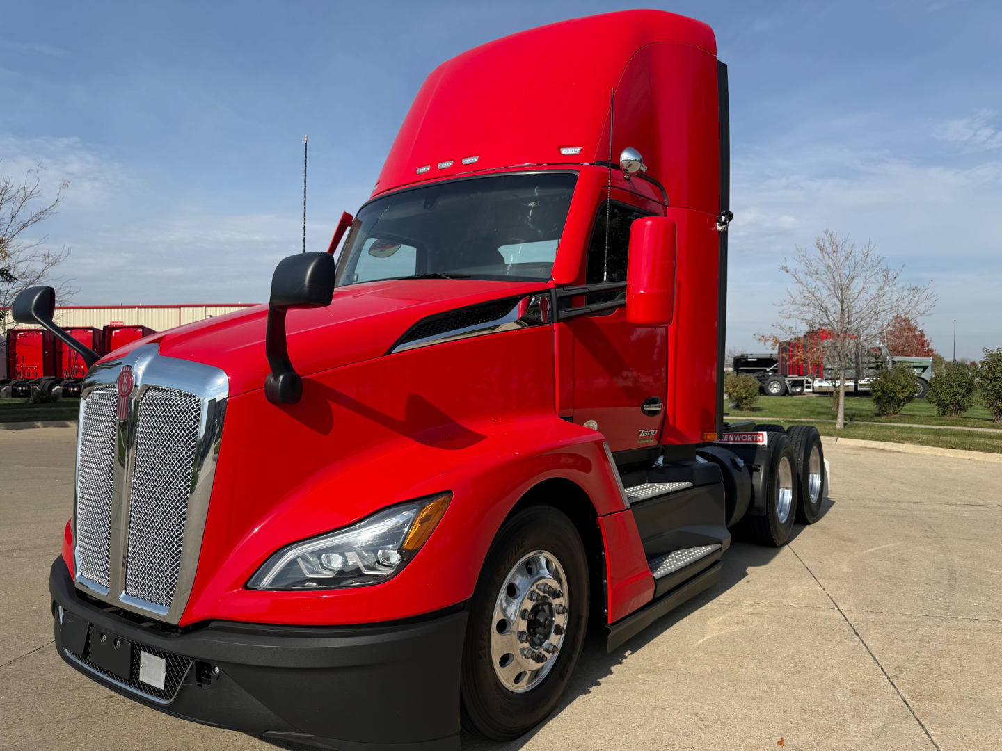 Kenworth T680 conventional daycab truck in red, front-left view, with chrome grille and large aerodynamic hood, dual rear axles, in-service condition.
