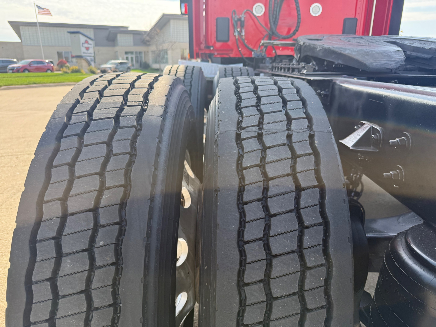 Kenworth T680 tractor-series dual rear tires and chassis view showing heavy-duty tread pattern and wheel hubs.