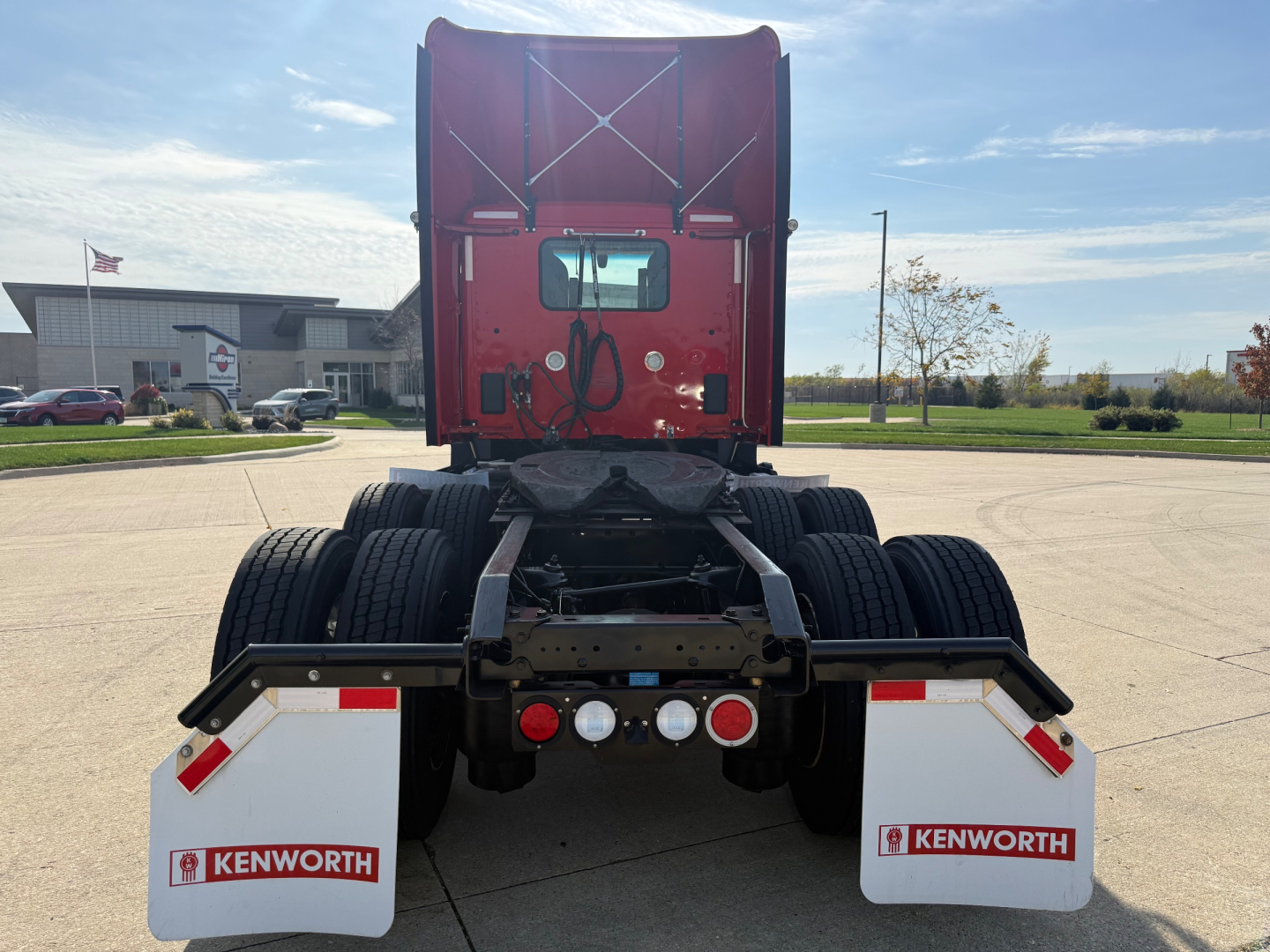 Kenworth T680 rear view showing chassis, dual rear axles, and mud flaps with Kenworth logos.