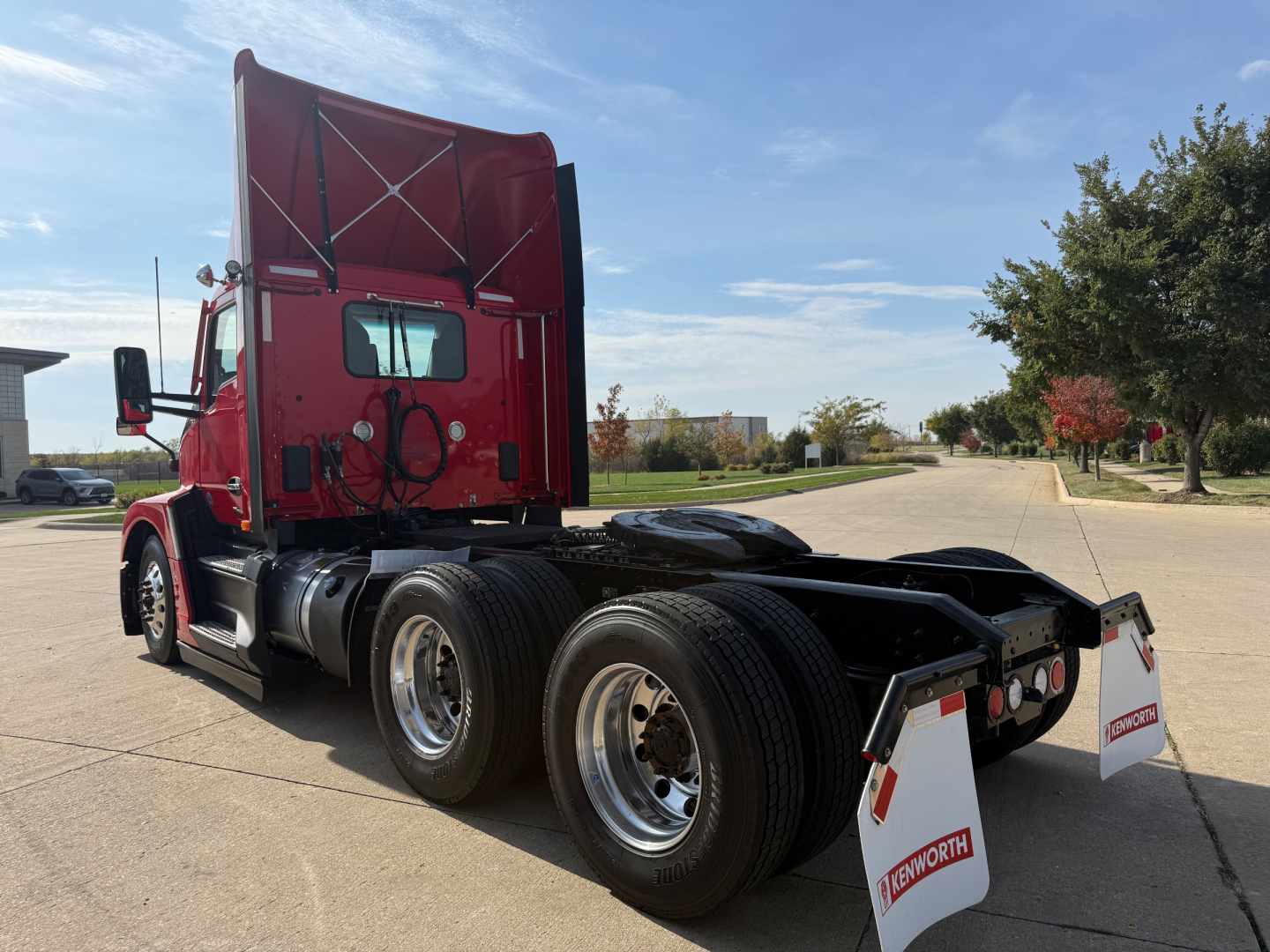 Kenworth T680 tractor back view showing dual rear axles and mud flaps with Kenworth branding.
