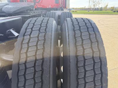 Dual rear wheels of a Kenworth T680 tractor showing treaded tires and axle area.