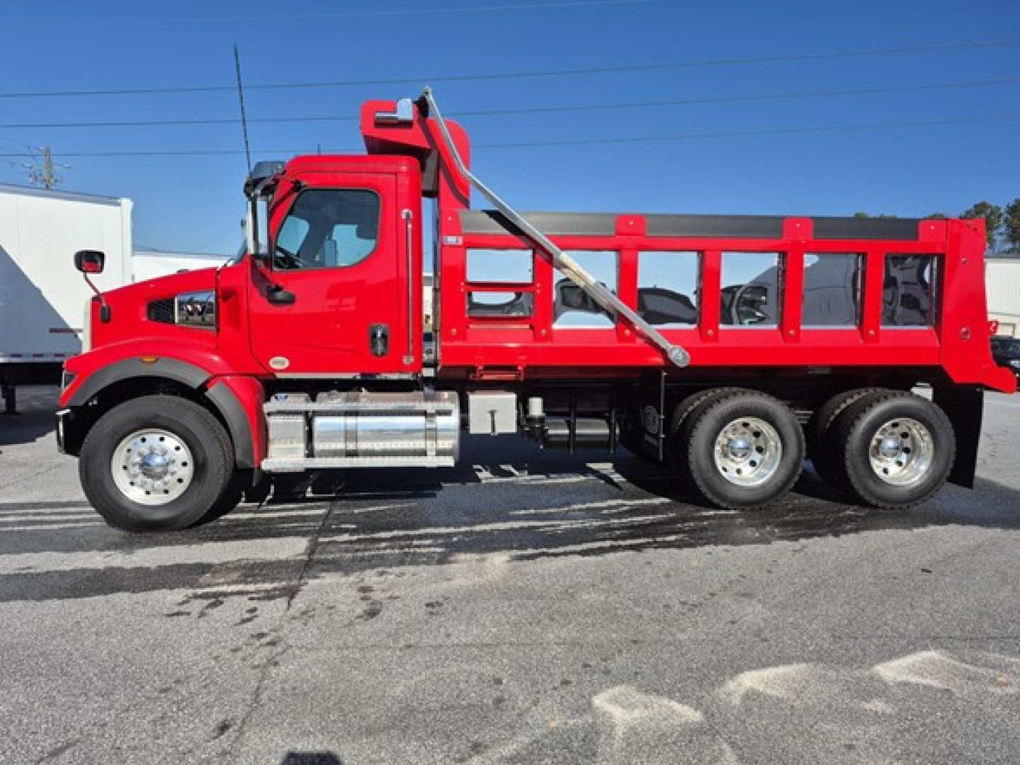 Western Star 47x dump truck in red side view showing cab, dump bed, and dual rear wheels.