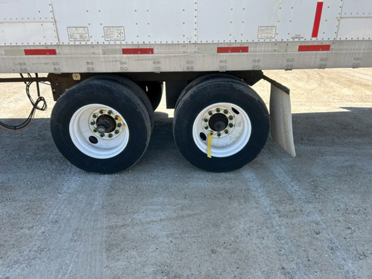 Dual rear trailer wheels and lower side of a 2005 Utility 4000D-X trailer showing twin tires and leaf spring suspension.
