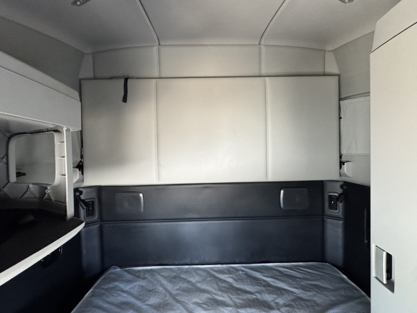 Kenworth T680 sleeper cab interior with bed and storage compartments visible