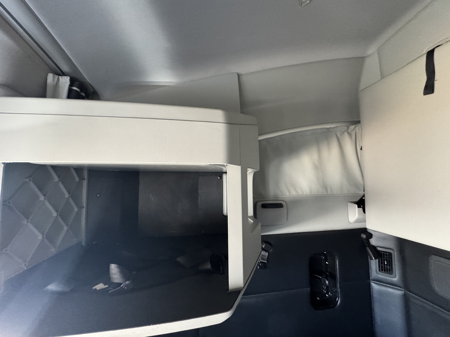 Interior view of a Kenworth T680 sleeper cab showing storage cabinet and dash area.