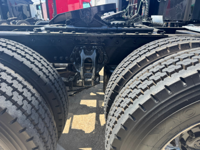 Kenworth T680 chassis showing dual rear wheels and suspension components; visible frame, leaf spring, and drivetrain area under trailer connection.