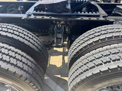 Kenworth T680 chassis view showing dual rear axles and suspension components with tires and undercarriage.