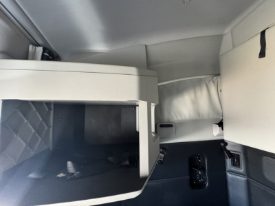 Interior view of a Kenworth T680 sleeper cab showing storage cabinet and dash area.