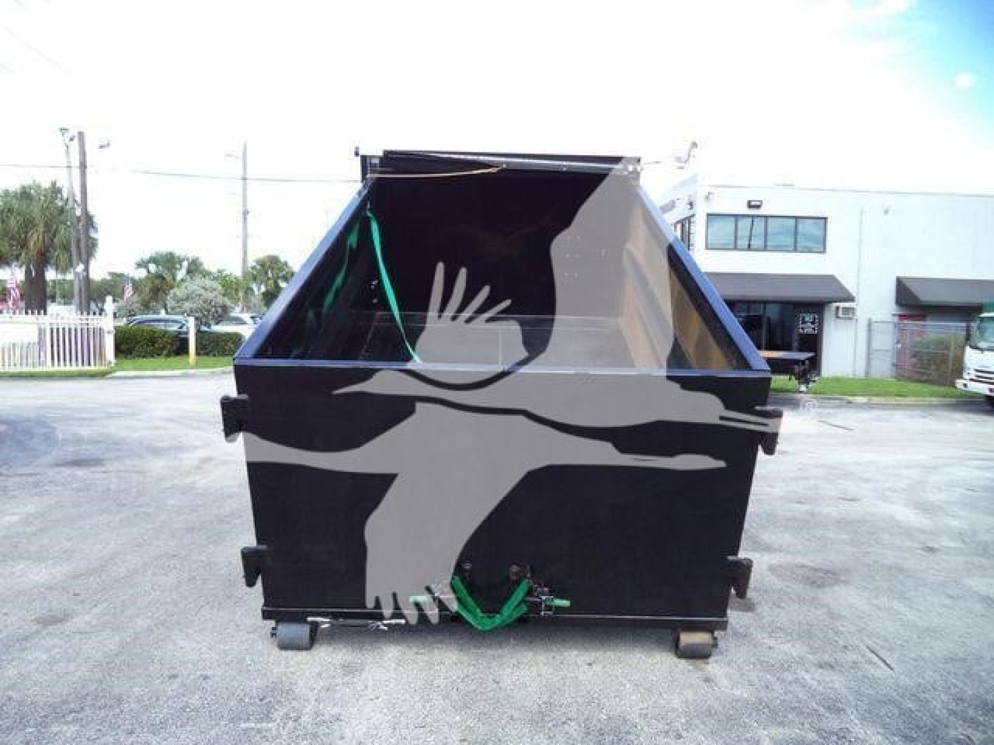 Isuzu NPR HD truck dump bed with hooklift in rear view showing tailgate and hydraulic hooks.