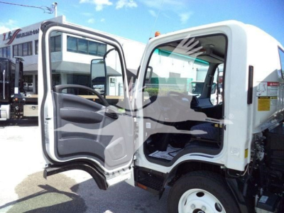 Isuzu NPR-HD truck cab with open doors; interior dashboard and steering wheel visible; white exterior; wheel and steps visible.