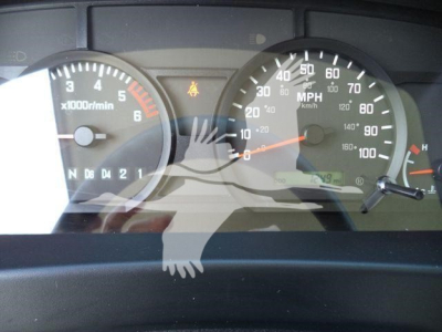 Isuzu NPR HD gauge cluster showing tachometer with x1000 r/min and speedometer with MPH, warning icons visible, steering dashboard reflection overlay.