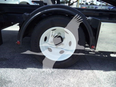 Isuzu NPR HD truck rear wheel area showing spare wheel mount and fender with wheel cover label text obscured by watermark.