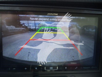 Isuzu NPR-HD truck rearview camera display showing parking guide lines on screen.