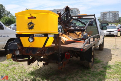 Ford F-250 Super Duty pickup with a yellow Fisher snow plow/salter attachment on a trailer hitch, rear view.