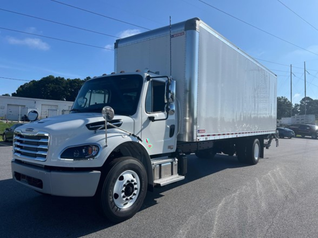 Volvo Freightliner Business Class M2 106 Plus box truck in serviceable condition showing cargo box and cab from driver side with VIN and stock information not visible.