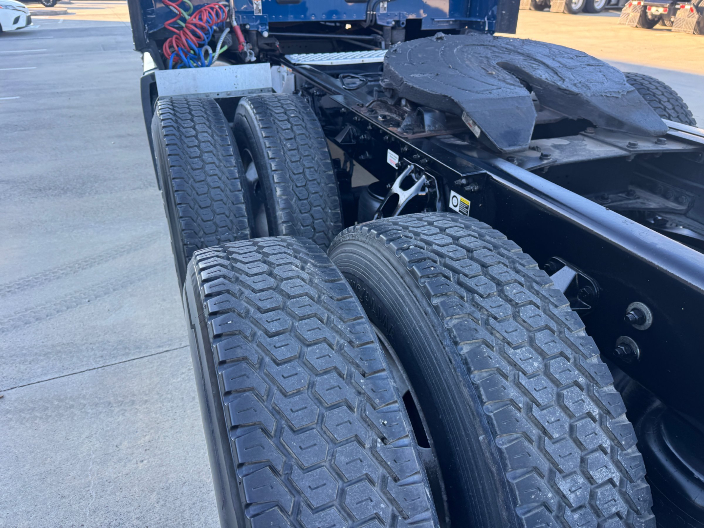 Kenworth T680 chassis showing dual rear axles and tire tread details with fifth wheel and frame rails visible.