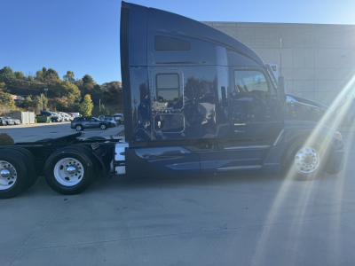 Kenworth T680 sleeper cab side view with black paint and chrome wheels; no visible branding text readable on body.