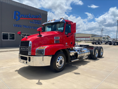 Mack AN64T conventional daycab truck in red exterior parked outdoors showing front and side, chrome bumper, dual rear axles, fuel tanks, and factory grille.