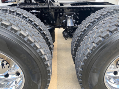Mack AN64T truck chassis showing dual rear axles with large tread tires and suspension components.