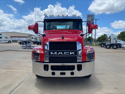 Front view of a red 2021 Mack AN64T conventional daycab truck with large chrome grille, bumper, and side mirrors in a parking lot.