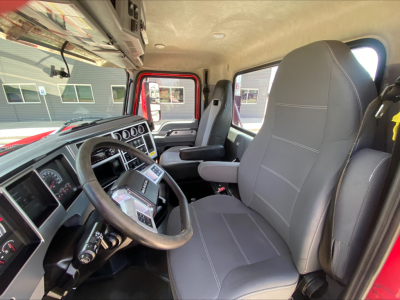 Cab interior of a 2021 Mack AN64T daycab showing steering wheel, dashboard with gauges, driver seat, and passenger seat