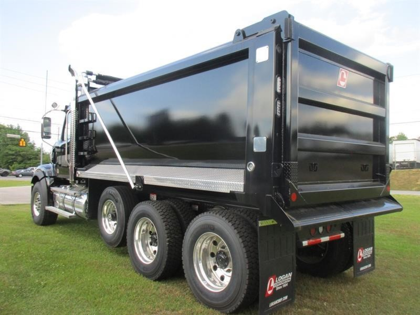 Western Star 49X dump truck in production model with dump bed and dual rear axles, side view showing wheels and hydraulic components.