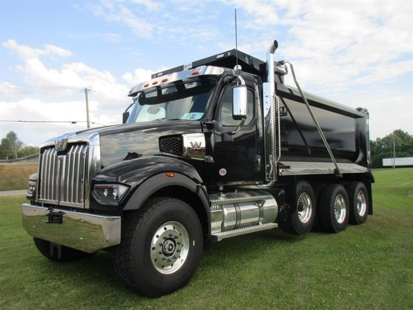 Western Star 49X dump truck in black showing front grille, dual rear axles, and chrome fuel tanks.